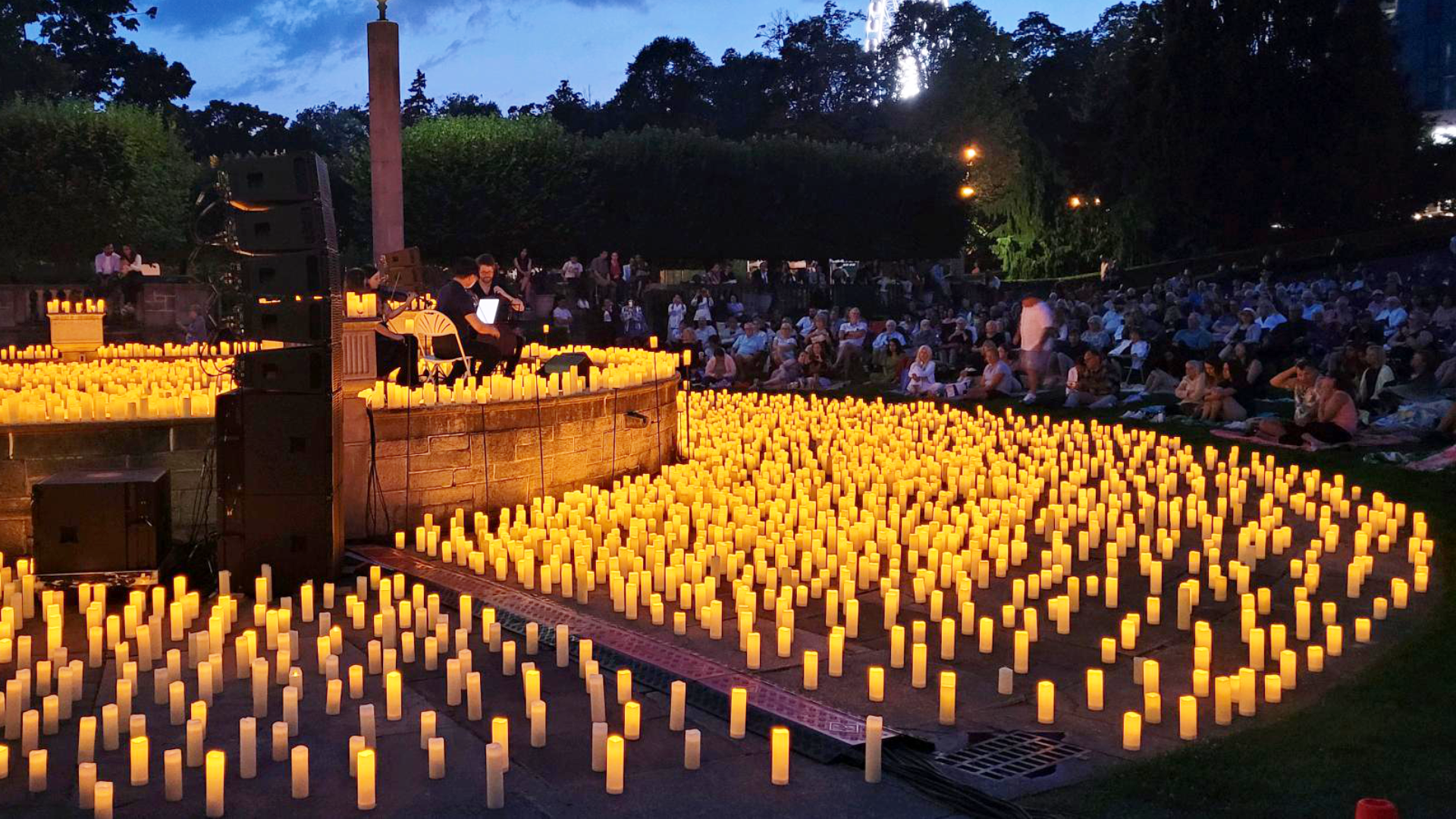 A concert in the park lit with hundreds of candles