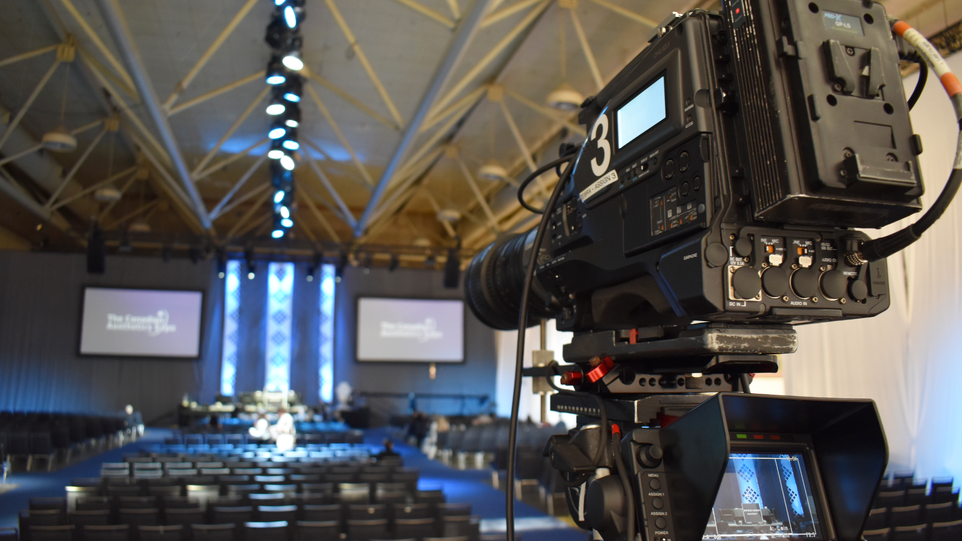 A camera is set up and pointed towards the keynote stage for the Canadian Association of Medical Aesthetics conference
