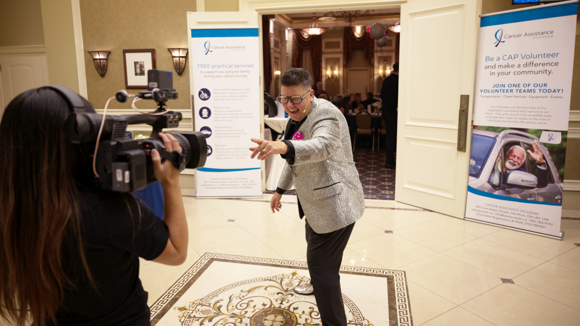 A presenter is filmed on their way to hosting the Cancer Assistance Program Gala
